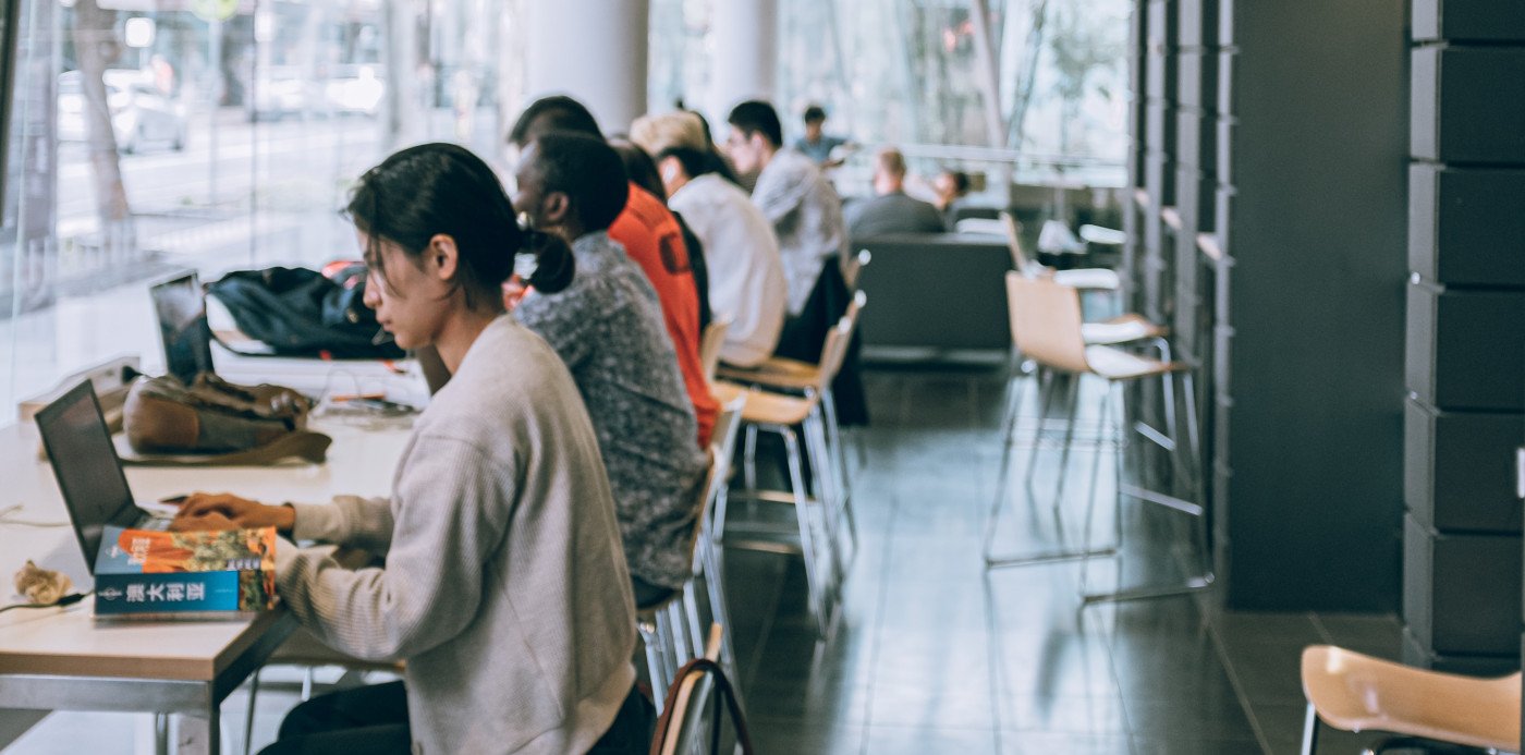 Estudiantes con portátiles en una biblioteca