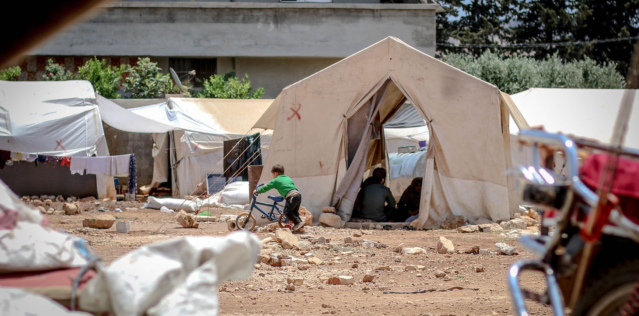 Un nen amb una bicicleta a un camp de refugiats