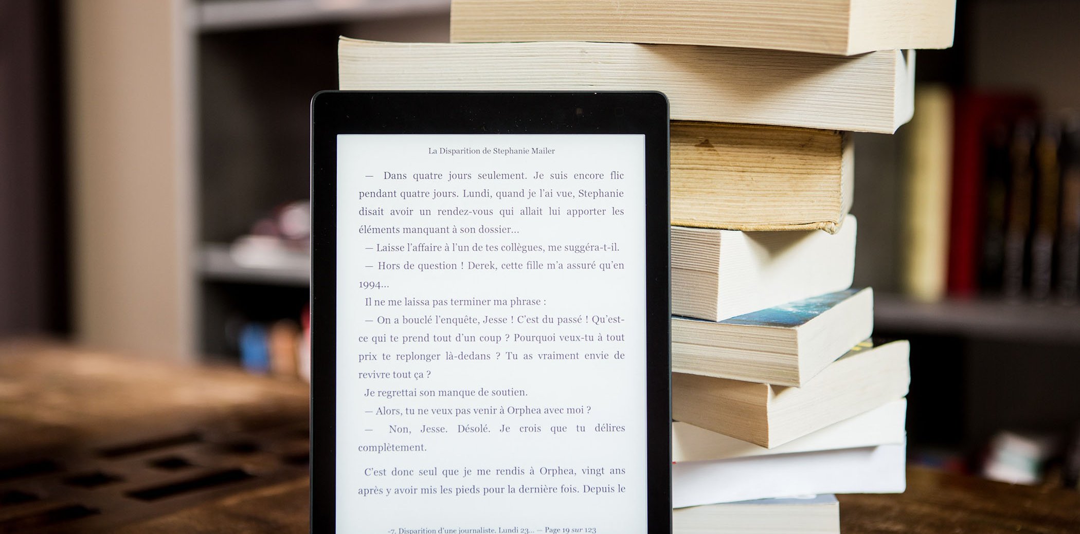 Un ebook al costat d'una torre de llibres