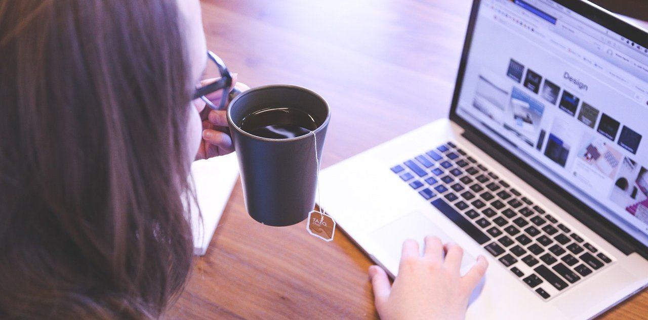 Mujer tomándose una taza de té mientras aprende en línea