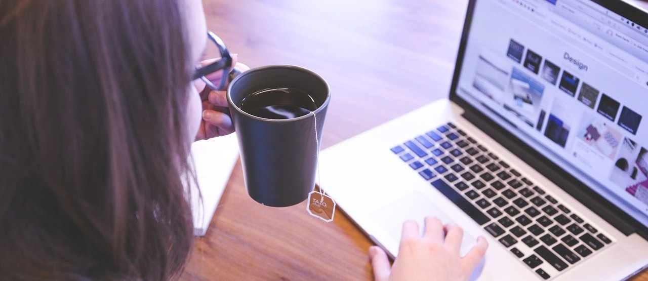 Mujer tomándose una taza de té mientras aprende en línea