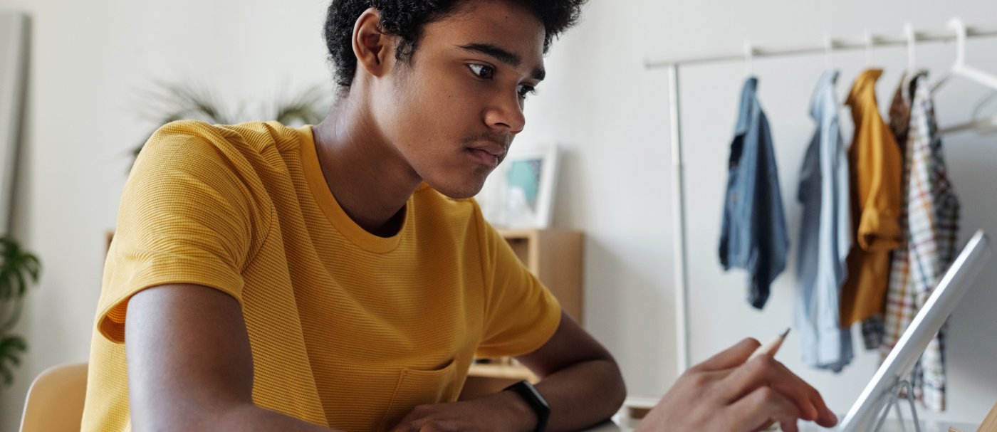 Un chico con un lápiz y una tablet