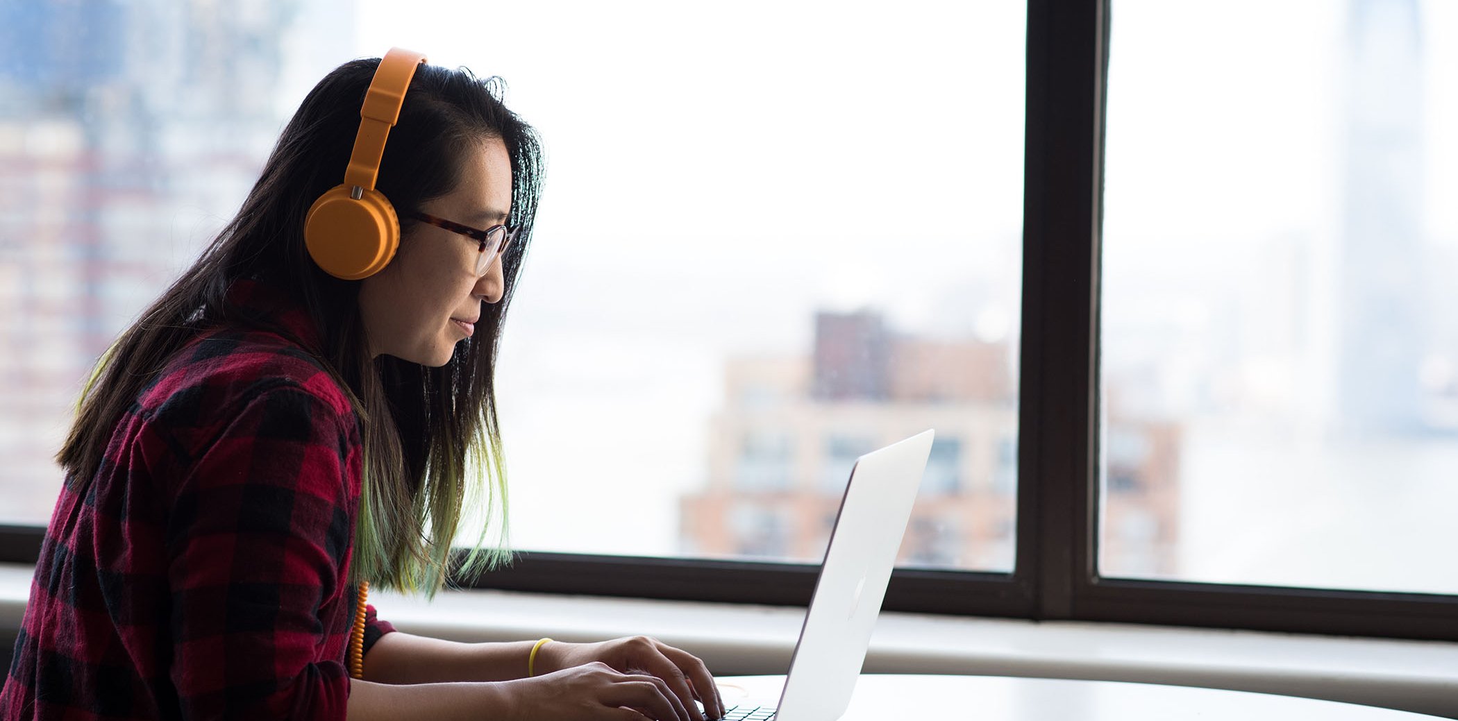 Una chica con un portátil y auriculares